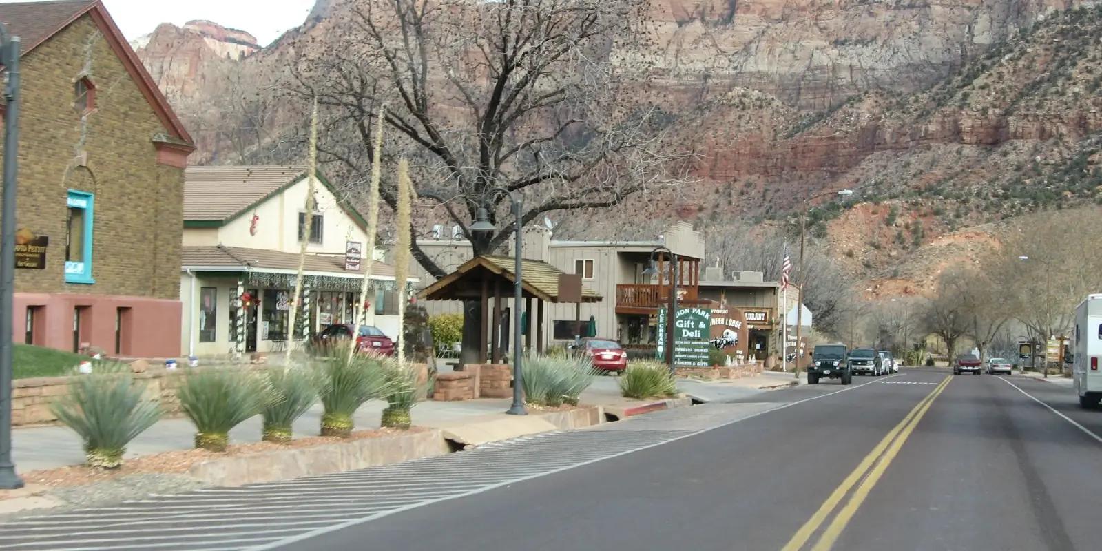 The main street of Springdale, Utah, with red cliffs of Zion National Park behind the town.