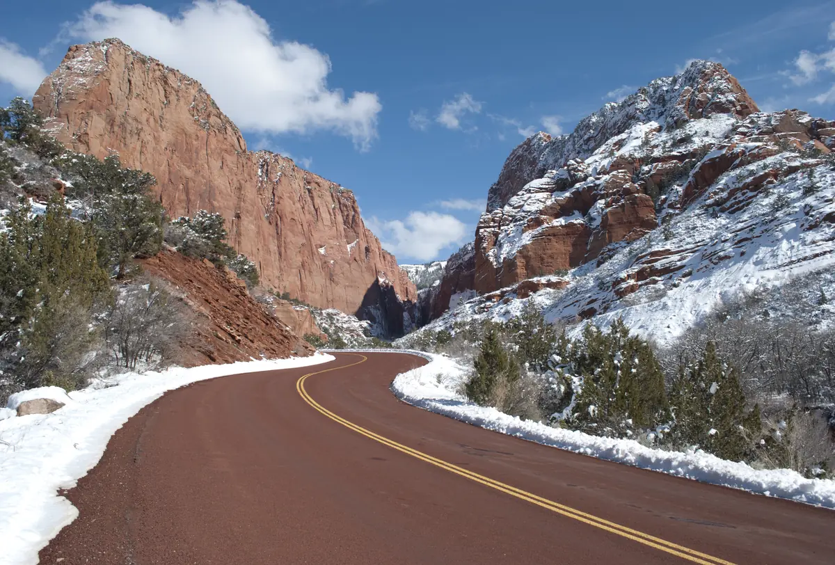 The Kolob Canyons Road curving between snow-dusted red cliffs after a winter storm, Zion National Park.