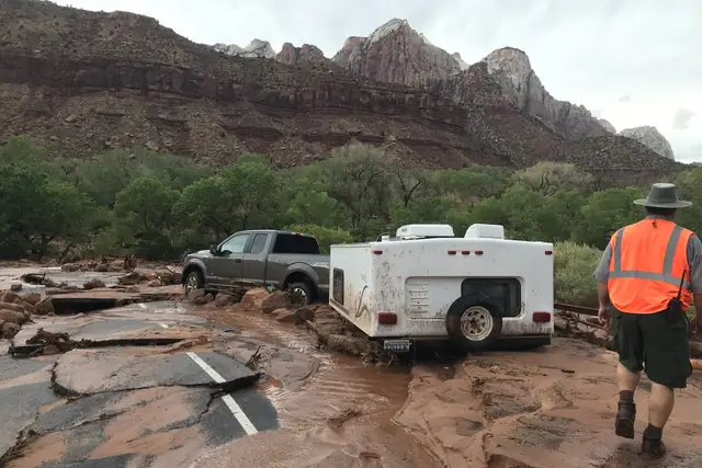 A truck stuck in mud in a parking lot broken up by flash-flood water near the South Entrance of Zion National Park.