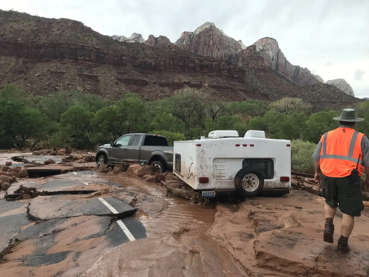 A truck stuck in mud in a parking lot broken up by flash-flood water near the South Entrance of Zion National Park.